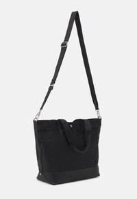 Czarna płócienna torba na ramię z regulowanym paskiem. Posiada podwójne górne uchwyty, teksturowane dno oraz zapięcie na zatrzask. Prosty i funkcjonalny design.