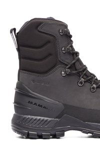 Svarta vattentäta vandringskängor med en texturerad överdel, förstärkt häl, metallöglor och en robust sula. Inkluderar GORE-TEX märkning.