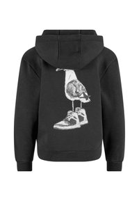 Sudadera negra con un gráfico de un pájaro de pie sobre unas zapatillas, impreso en blanco en la parte posterior. Tela suave con un corte relajado.