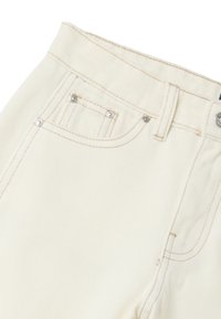 Jeans de denim color crema con cintura alta, con costuras de cobre, dos bolsillos frontales y cierre de botón de metal.