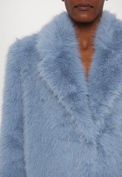 Abrigo de pelaje sintético azul claro con un collar ancho, que presenta una textura suave y una apariencia densa y esponjosa. Sin cierres ni patrones visibles.