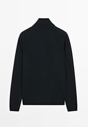 Maglione nero a maniche lunghe con collo a dolcevita steso, visto da dietro su uno sfondo bianco.