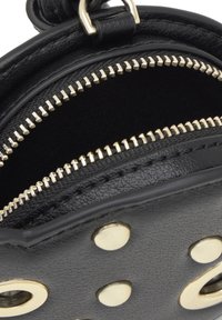 Czarna skórzana torba ze złotym okuciem, z zamkiem błyskawicznym i okrągłymi ćwiekami. Wnętrze wyłożone jest jednolitym czarnym materiałem.