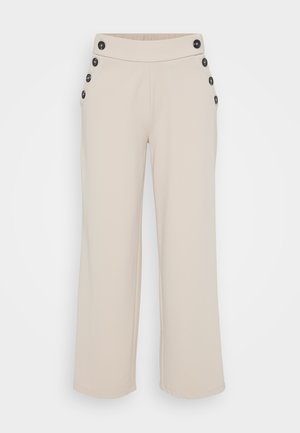 Pantalones de pierna ancha de color beige con cintura alta y botones negros dispuestos en dos filas verticales a cada lado de la pretina.