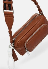 Borsa a tracolla in pelle marrone con finitura strutturata, dotata di cerniere in argento, una tracolla removibile e un'accento in pelle bianca.