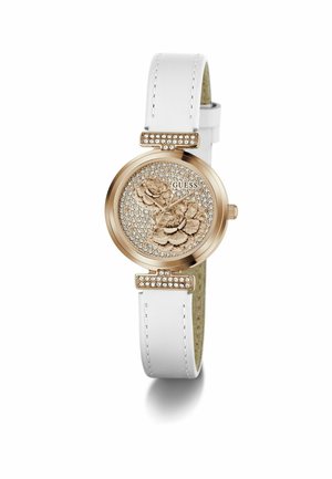 Reloj Guess con caja redonda de tono dorado, correa de cuero blanco, esfera con diseño floral y cristales, y detalles en tono plateado. Detalles en oro rosa.