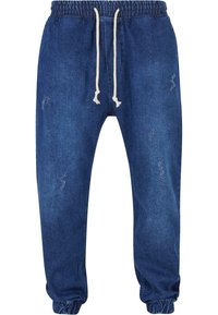 Joggers de mezclilla en azul oscuro con una cinturilla elástica con cordones, puños ajustados y sutiles detalles desgastados.
