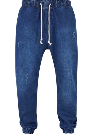 Joggers en denim bleu foncé avec une taille élastique et un cordon de serrage, des poignets resserrés et des détails légèrement déchirés.