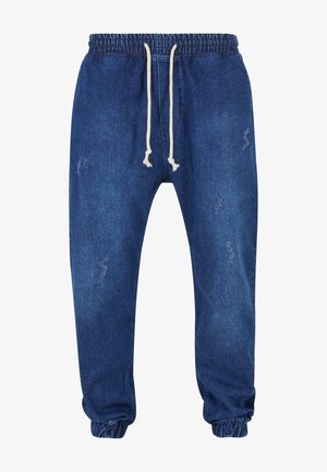 Joggers en denim bleu foncé avec une taille élastique et un cordon de serrage, des poignets resserrés et des détails légèrement déchirés.