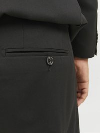 Black suit trousers featuring a back pocket with a button closure, smooth texture, and tailored fit, highlighting a classic design.