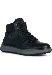 Botas de senderismo de cuero negro con un acabado texturizado, cuello acolchado y suela de goma gris con un patrón de banda de rodadura resistente.