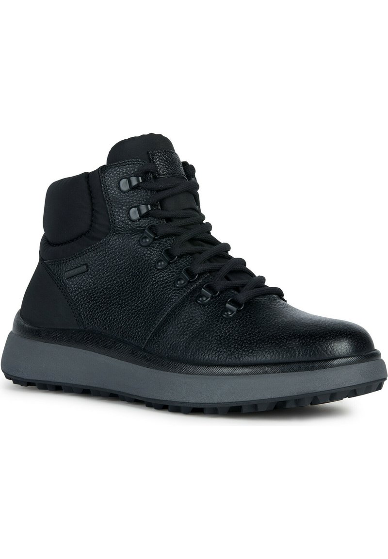 Bottes de randonnée en cuir noir avec une finition texturée, un col rembourré et une semelle en caoutchouc grise dotée d'un motif de crampons robuste.