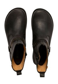 Botas negras hasta el tobillo con un exterior de cuero suave, punteras redondeadas, cremalleras laterales y un interior contrastante en tonos marrón claro. Suelas planas y hardware mínimo.