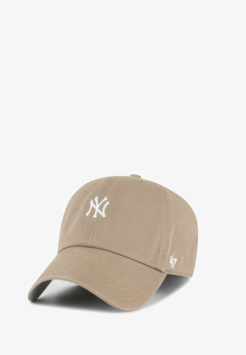 Beige baseball cap with white New York Yankees logo on front and small '47' logo on side, curved brim, fabric material.