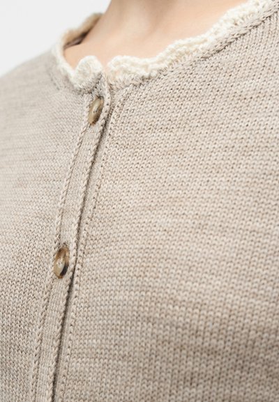 Cardigã bege de malha com acabamento texturizado, apresentando uma gola franzida e dois botões castanhos na frente.