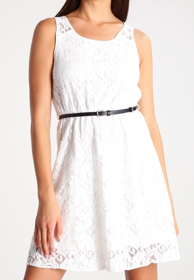 Robe en dentelle blanche avec un col rond, sans manches et une taille ceinturée noire. Motif floral texturé à l'ourlet.