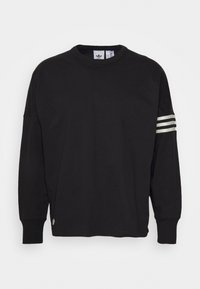 Černá mikina s dlouhým rukávem z bavlny, s kulatým výstřihem, volným střihem a třemi bílými pruhy na levém rukávu.