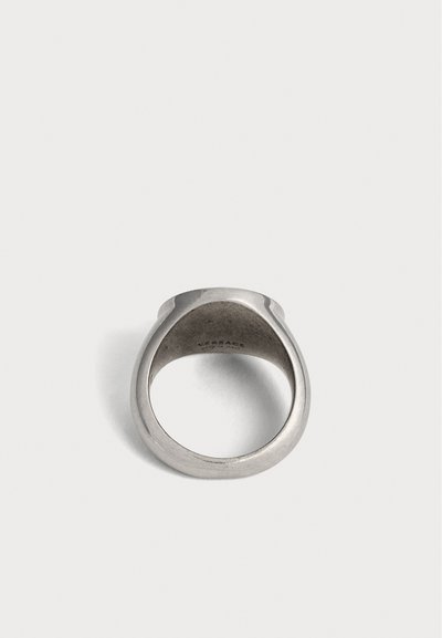 Bague chevalière Versace argentée vue de l'intérieur, mettant en avant la bande lisse et arrondie ainsi que la gravure subtile de la marque.