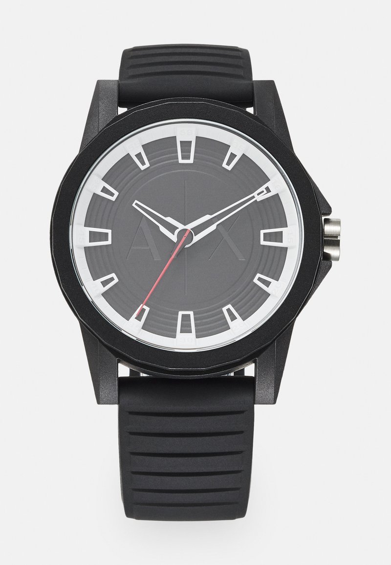 Reloj deportivo negro con caja redonda, correa de silicona texturizada negra, marcadores de hora blancos y segundero rojo sobre un fondo negro.