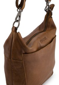 Sac à main en cuir marron avec une surface douce et texturée, fermeture éclair et une poche avant. Comporte également des finitions en métal et une bandoulière détachable.