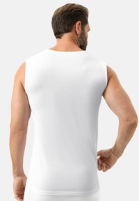 Biała sportowa koszulka bez rękawów z teksturowaną tkaniną, z okrągłym dekoltem i dopasowanym krojem, z gładkim tyłem.