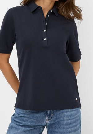 Marineblauw poloshirt van katoenen stof met een kraag, een drieknopsbies en zijslitten aan de zoom voor meer bewegingsvrijheid.