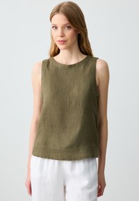 Top senza maniche in lino verde oliva con scollo rotondo e orlo dritto, abbinato a pantaloni in lino bianchi. Tessuto liscio, vestibilità casual.