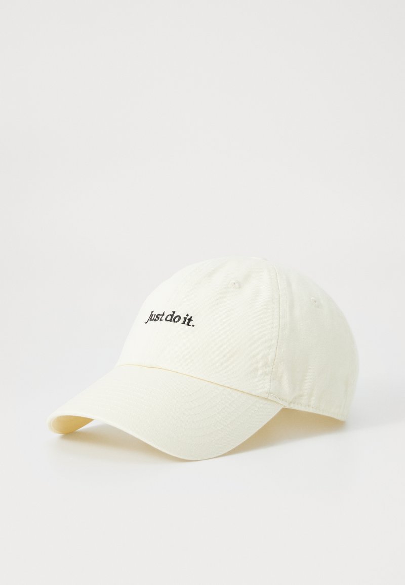Baseballmütze aus leichtem cremefarbenem Baumwollstoff, mit einem gebogenen Schirm und gesticktem Text "just do it." in Schwarz auf der Vorderseite.