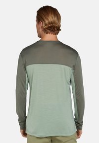 Langärmliges Shirt in Hellgrün mit dunklen grünen Akzenten, aus einem weichen Stoff gefertigt, mit einem lässigen Schnitt und gesteppten Details.