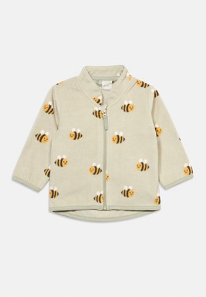 Jachetă din fleece bej deschis cu fermoar frontal, cu un model de albine zâmbitoare galbene și negre cu aripi albe.