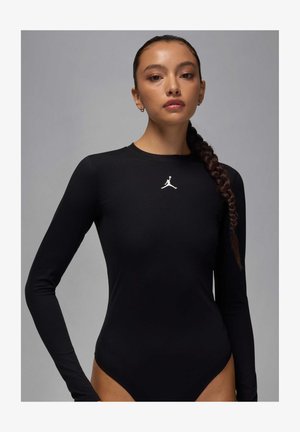 Czarny body z długim rękawem wykonane z gładkiego materiału, z białym logo Jordana na klatce piersiowej oraz wysokim krojem nogawek.
