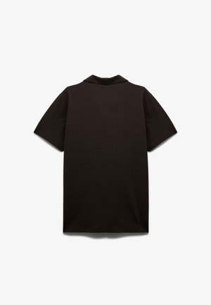 Black polo shirt, short sleeves, soft cotton material, flat collar, simple design, solid color, no visible patterns or embellishments.