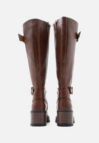 Brown leather knee-high boots with a thick block heel, featuring a zipper, leather straps, and sleek, smooth texture.