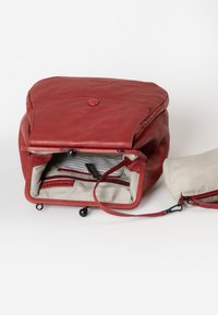 Rode leren rugzak met een afgeronde bovenkant, gestreepte stoffen voering, binnenzakken en een kleinere bijpassende pouch met een rits.