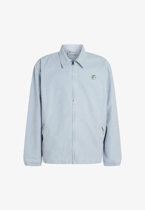 Light blue zip-up jacket in a soft, smooth fabric with a collared neckline, elastic cuffs, and side pockets. Features a small logo on the chest.