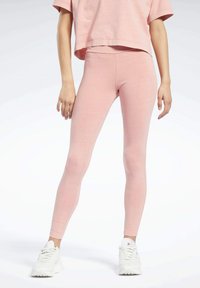 Rózsaszín leggings szűk fazonban, puha anyagból k�észült. Magas derékkal és sima textúrával rendelkezik. Megfelelő crop toppal és fehér sportcipővel viselve.