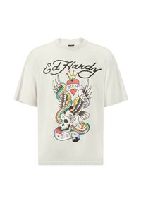 Camiseta blanca de algodón con un colorido gráfico de estilo tatuaje que presenta una calavera, un águila, un corazón y serpientes. Texto en estilo "Ed Hardy" encima del diseño.