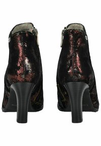 Botines negros hasta el tobillo con un acabado texturizado y brillante. Presentan un tacón curvo y un zipper lateral. Acabados con un toque de rojo metálico.