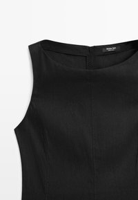 Schwarzes ärmelloses Kleid mit Boot-Ausschnitt und sichtbarer Mittelnaht, zeigt den oberen Vorderbereich und den Kragenbereich.