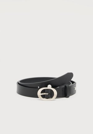 Ceinture en cuir noir enroulée avec boucle ovale en métal argenté et petit détail en perle sur un fond clair uni.