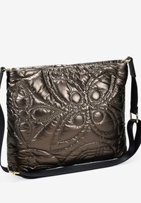 Bolso metálico bronce acolchado con asa negra, que presenta intrincados patrones de costura en relieve y una textura suave y acolchada.