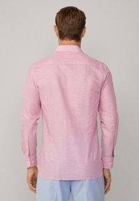 Red and white striped long-sleeve shirt with a pointed collar, button cuffs, and a straight hem. Back view shows seam detailing.
