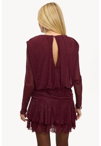 Robe bordeaux à pois blancs, manches longues en voile transparent, ourlet à volants et détail dos ouvert. Tissu doux et léger avec une taille cintrée.