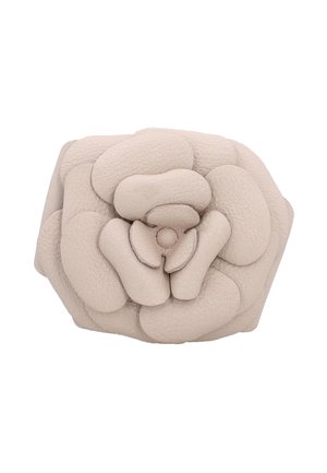 Weiches hellbeiges Lederetui in Form einer geschichteten Blume mit strukturierten Blütenblattdetails.