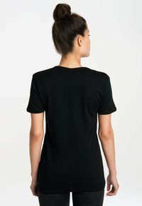 Black cotton t-shirt with short sleeves, a rounded neckline, and a relaxed fit. Smooth texture with no visible patterns or graphics.