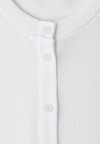 Cardigan en maille blanc devant avec un col rond côtelé et trois boutons blancs fermés au centre.