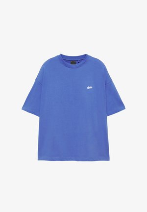 T-shirt bleu oversize à manches courtes avec col rond et petit logo blanc sur la poitrine gauche.