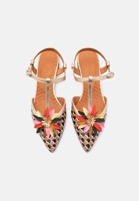 Sandales à bout pointu avec une surface à motifs noir et marron, des brides métalliques dorées, et un accent floral comprenant des éléments roses, rouges et verts.