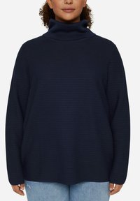 Maglione a collo alto blu navy con un design a coste testurizzato, dotato di maniche lunghe e una vestibilità ampia e comoda.
