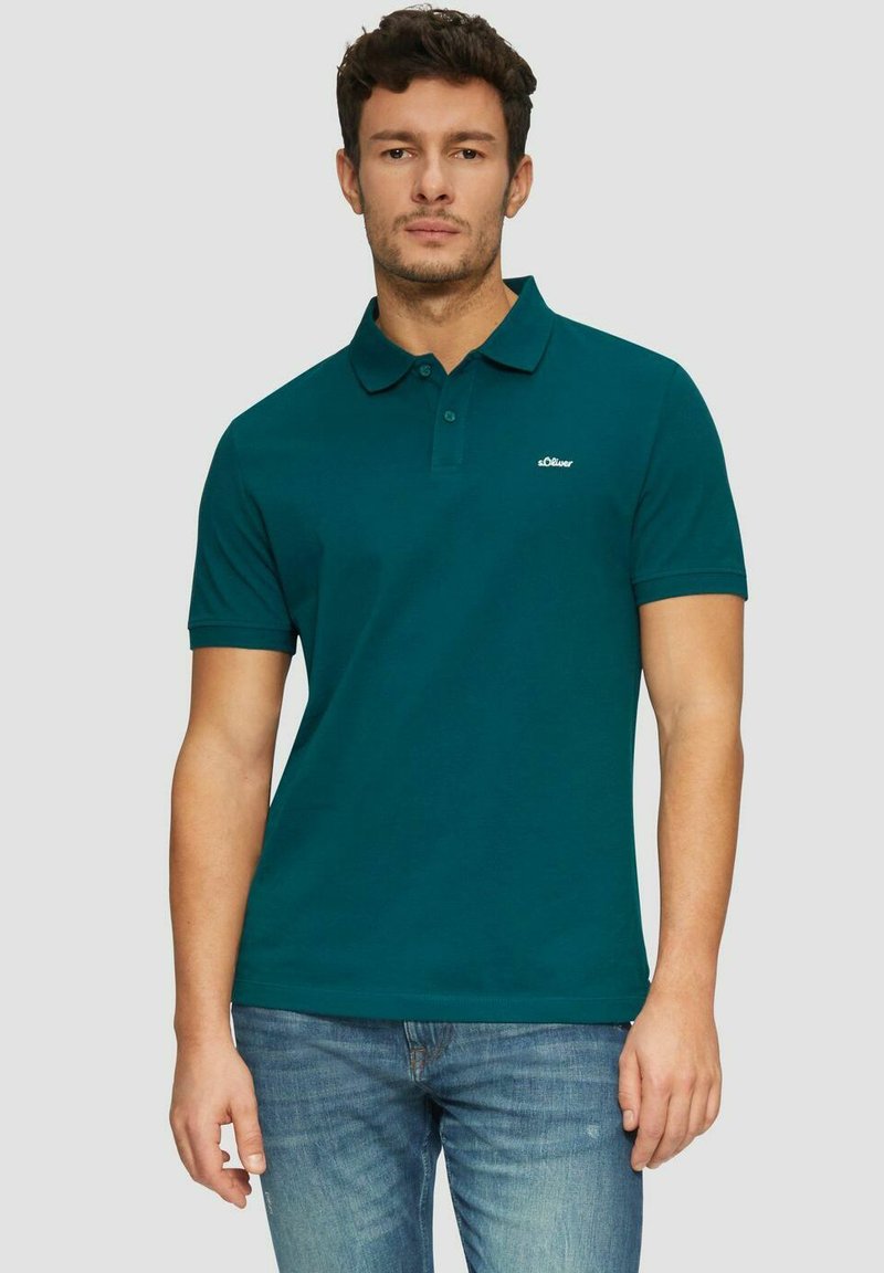 Türkisfarbener Poloshirt mit klassischem Kragen, Zweiknopf-Leiste, kurzen Ärmeln und kleinem Logo auf der linken Brust. Aus Baumwollstoff, lockere Passform.